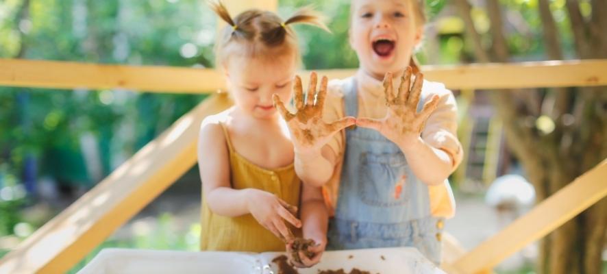 Dos niñas jugando con barro, estimulación sensorial